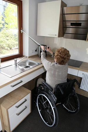 Rollstuhlfahrerin öffnet Fenster mit Fensteröffner