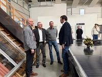 Unternehmenbesuch SEN Solare Energiesysteme GmbH vier Männer unterhalten sich in einer Halle